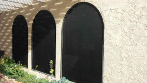 Oversized arched windows with 90% solar screens and bronze frames